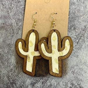 Detail of cactus-shaped wooden earrings with leopard print hair inlay and gold ear hooks