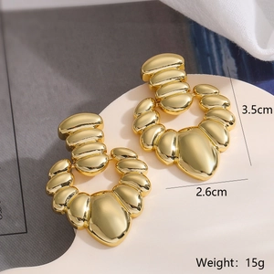 Detail view of gold irregular geometric earrings on a stand with size and weight info