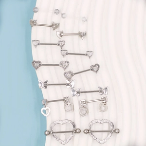 Detailed close-up of silver surgical steel heart and butterfly nipple rings with cubic zirconia