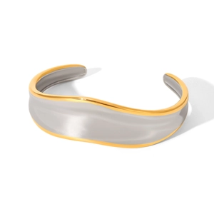Detail of wave-shaped wide bangle in two-tone silver and gold stainless steel finish