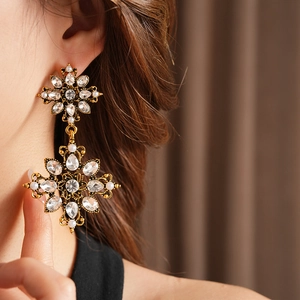 Gros plan de boucles d'oreilles vintage dorées avec cristaux et perles sur mannequin