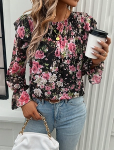 Detail of floral print chiffon blouse with ruffled cuffs and smocked neckline