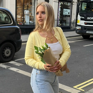 Gros plan sur un cardigan tricoté jaune clair ajusté avec des boutons dorés de style urbain