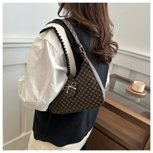 Detail of vintage half-moon shoulder bag with retro polka dots and silver bow ornament
