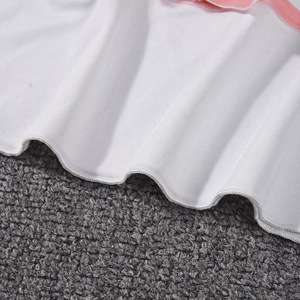 Detailed macro view of white ribbed knit fabric with delicate pink velvet piping