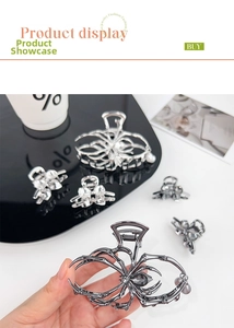 Close-up of gothic silver spider hair claw and bow clip with grey pearl charms