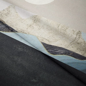 Close-up of soft short-pile tapestry featuring abstract blue and gold mountain patterns