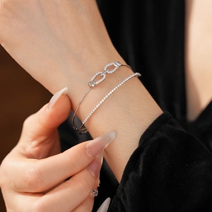 Gros plan d'un bracelet double couche en argent et zircons au poignet avec maillons