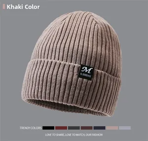 Detailed close-up of khaki ribbed knit beanie with stylish square brand label on cuff