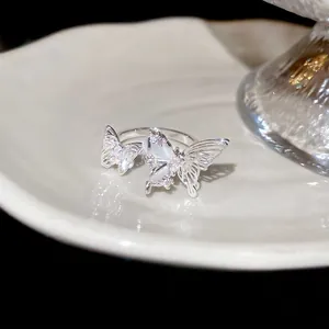 Elegant silver butterfly open ring with zircon inlay and opal texture on a ceramic tray