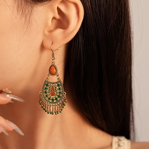 Close-up of bohemian tassel earrings with vintage gold metal and colorful beads