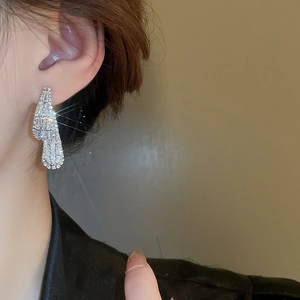 Close-up of sparkling cubic zirconia square hoop earrings worn by a female model