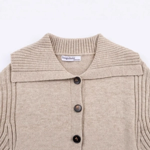 Front view of beige knit cardigan with oversized navy collar and deep brown buttons