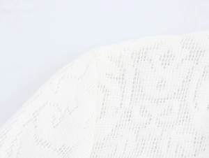 Nahaufnahme von weißem Spitzenstoff mit feiner Stricktextur und Hohlmustern im Detail
