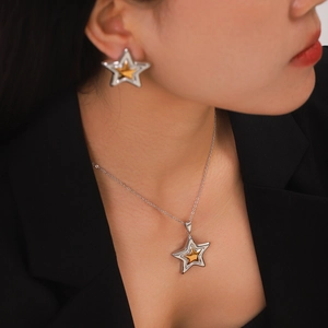 Two-tone stainless steel star pendant necklace and earrings set on female model