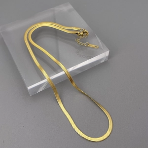 Detail of gold double snake chain showing S925 tag, lobster clasp and extension link