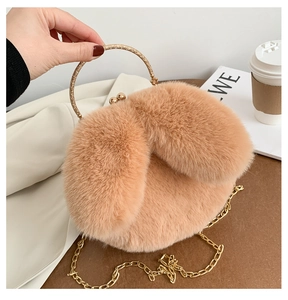 Close-up of plush camel handbag featuring a golden circular handle and retro metal clasp