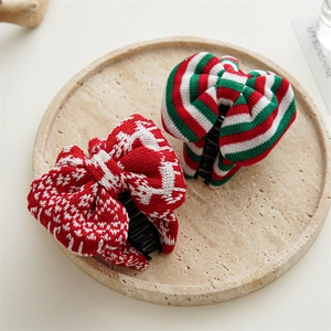 Close-up of festive knit Christmas bow hair clips with reindeer and stripe patterns