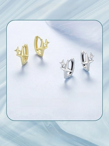 Detailed view of gold and silver S925 sterling silver star hoop earrings on blue silk
