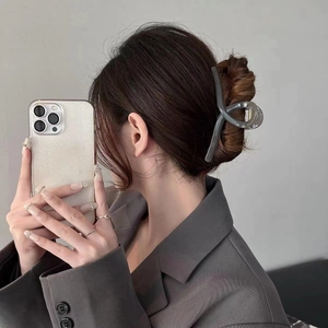 Translucent grey curved hair claw clip for thick hair shown on elegant model