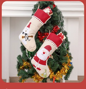 Détail de chaussettes de Noël avec motifs ours et Père Noël suspendues sur l'arbre décoré