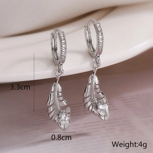 Detail view of gold-plated feather earrings with zircon inlay showing 3.3cm size
