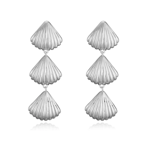 Detail view of silver shell drop earrings with textured metallic finish on white background