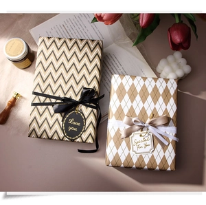 Close-up of premium gold wave and diamond pattern gift wrapping with silk ribbons