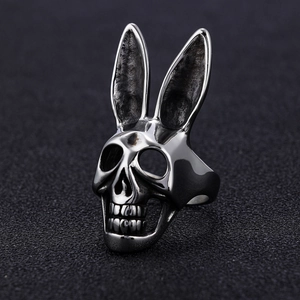Detail macro view of Gothic silver bunny skull ring on a textured black background