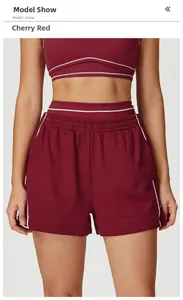 Dettaglio degli shorts sportivi rosso ciliegia a vita alta con piping bianco ed elastico