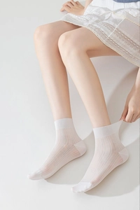 Detail of white thin mesh socks showing high elasticity and breathable rib texture