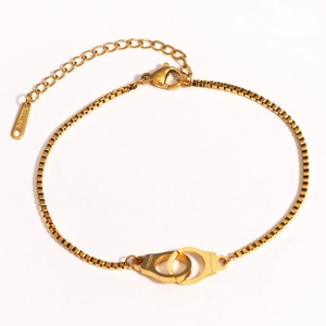 Dettaglio della collana a manette dorate con catena a scatola e chiusura a moschettone
