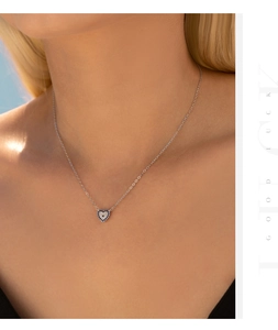 Detail of S925 silver heart necklace with blue and white zircon on a female model