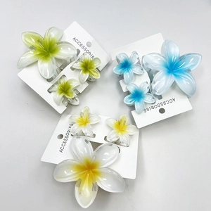 Three-piece plumeria flower hair claw set in green, blue, and yellow tropical designs