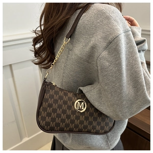 Close-up of brown vintage shoulder bag with M-letter print and gold chain strap detail
