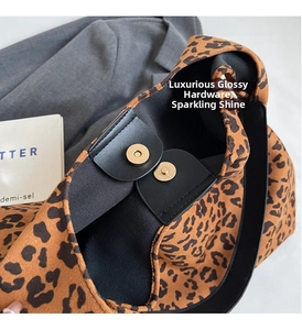 Detail of golden magnetic buckles and leopard print suede texture on the fashion tote bag