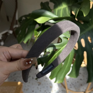Texture détaillée du bandeau en maille côtelée gris foncé avec étiquette fait main