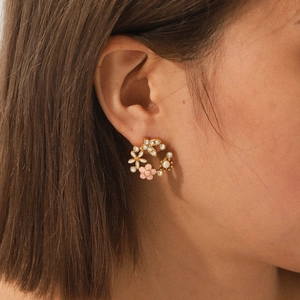 Boucles d'oreilles couronne de fleurs en acier doré 18K avec zircons et perles sur modèle