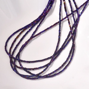 Close-up of 2mm iridescent purple-blue hematite cube beads for jewelry making