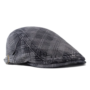 Detail of dark grey washed denim newsboy cap with classic metal side buckle and stitching