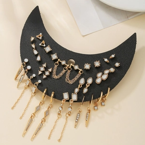 Détail de boucles d'oreilles dorées avec opales et chaînes sur présentoir lune