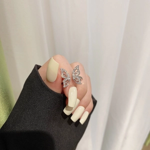 Detail showing an elegant silver bow ring with shimmering pave-set stones on hand