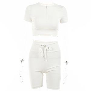 Close-up of white ribbed two-piece set featuring half-zip crop top and high-waist shorts