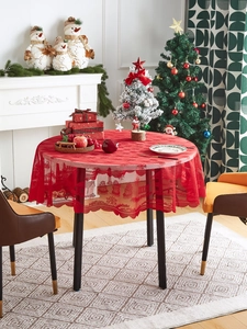 Close-up of a festive red lace tablecloth with Christmas patterns on a round table