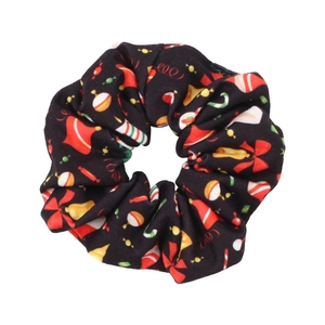 Detail of black Christmas scrunchie with festive bells, candies and bow patterns