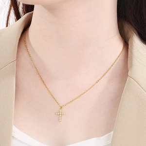 Elegant gold stainless steel cross necklace with cubic zirconia on female model