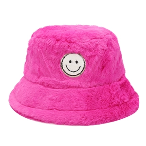 Fuchsia plush bucket hat for women featuring a white smiley face patch for winter warmth
