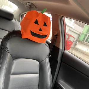 Halloween pumpkin car headrest cover made of orange non-woven fabric for festive decor