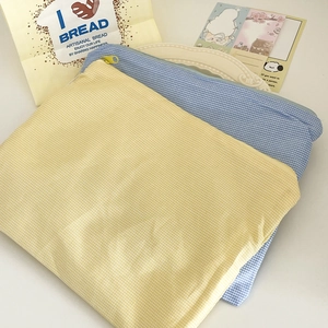 Detail of plaid cosmetic bags in yellow and blue with zippers and cotton-linen texture