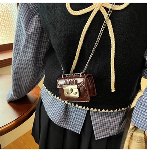 Detail view of mini red lychee pattern crossbody bag with silver chain on model back